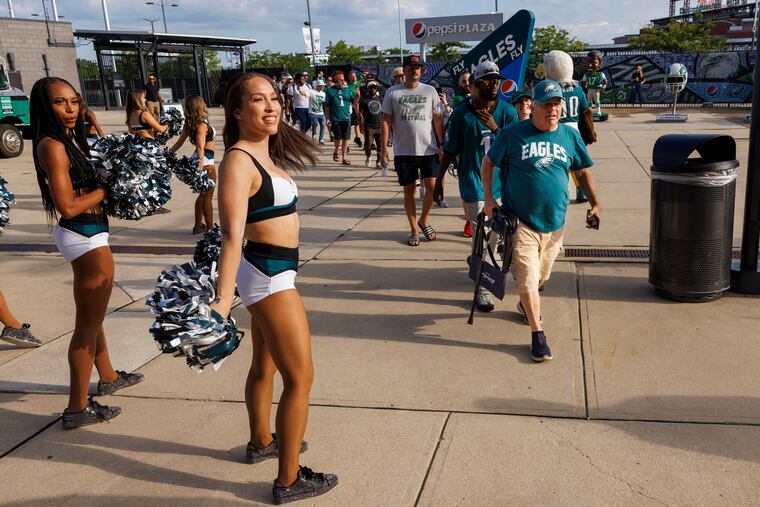 Eagles cheerleaders greet fans arriving to buy new kelly green team merchandise. Philadelphia Eagles fans gathered outside the Lincoln Financial Field and Pro Shop to buy Eagles kelly green merchandise on Monday morning July 31, 2023.