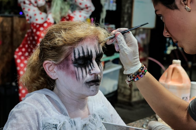 Makeup artist Nicolette Procopio (right) works on Charmaine Warrington, a 52-year-old haunter at Fright Factory in South Philly, on Friday, October 6, 2023.