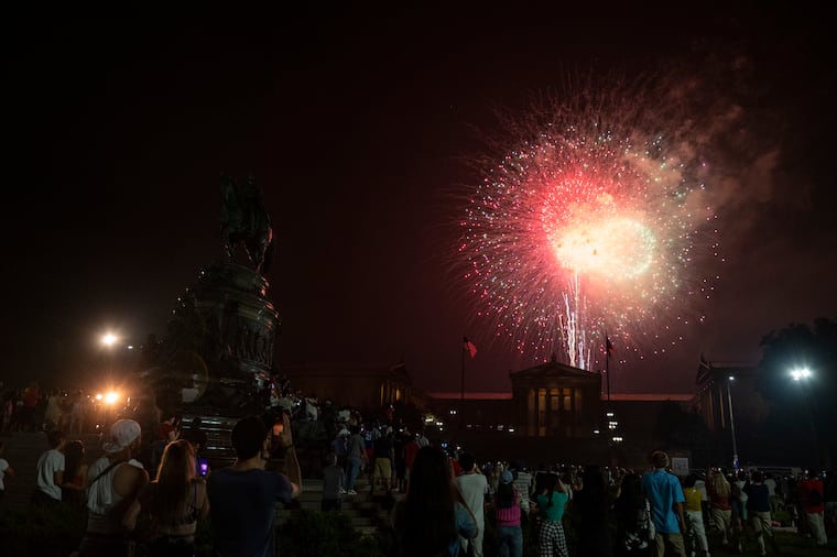 A crowd of people in Eakin’s Oval watch the fireworks over the Philadelphia Museum of Art on July 4, 2023.