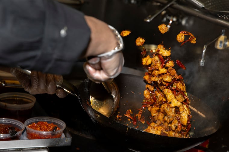 Jun Du prepares dry pepper chicken at DanDan in Suburban Square.