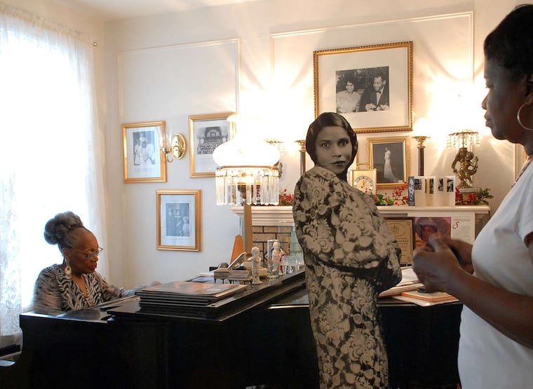 Blanche Burton-Lyles, founder of the Marian Anderson Historical Society, plays piano at the Marian Anderson Residence and Museum as Cheryl Gay listens.